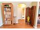 Hallway with bookshelf and partition, leading to a door and bathroom, on hardwood flooring at 5769 E Price Blvd, North Port, FL 34288