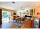 Bright living room features wood floors, a ceiling fan, comfortable seating and sliding glass doors to the pool at 5769 E Price Blvd, North Port, FL 34288