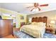 Comfortable bedroom features hardwood floors, ceiling fan, ensuite bathroom access, and closet space at 5769 E Price Blvd, North Port, FL 34288