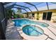 Enclosed pool area with clear blue water, in-ground jacuzzi, seating and a covered patio at 5769 E Price Blvd, North Port, FL 34288