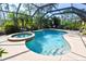 Screened-in swimming pool with hot tub and outdoor seating provides a relaxing backyard oasis at 5769 E Price Blvd, North Port, FL 34288