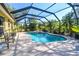 Backyard enclosed pool area with clear blue water, in-ground jacuzzi, seating and lush tropical landscaping at 5769 E Price Blvd, North Port, FL 34288