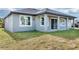 Backyard view of gray house featuring covered patio and sliding glass doors at 3664 Ribera Ave, North Port, FL 34286