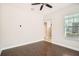 Bright bedroom featuring hardwood floors, a ceiling fan, and a large window at 6160 Castleton Hollow Rd, Riverview, FL 33578