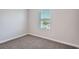 Cozy bedroom with neutral walls, plush carpet, and a bright window bringing natural light in at 6160 Castleton Hollow Rd, Riverview, FL 33578