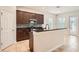Open kitchen with an island, dark wood cabinets, stainless steel appliances, and a tile backsplash at 6160 Castleton Hollow Rd, Riverview, FL 33578