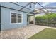 Covered patio with brick pavers, green lawn and a view of the blue house at 6160 Castleton Hollow Rd, Riverview, FL 33578