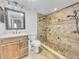 Tiled bathroom with a walk-in shower, modern vanity, and good lighting at 557 Pinellas Bayway S # 111, St Petersburg, FL 33715
