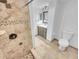 Bathroom featuring walk-in shower, vanity with sink, and toilet at 557 Pinellas Bayway S # 111, St Petersburg, FL 33715