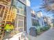 Townhouse exterior featuring a wooden spiral staircase and screened porch in a landscaped community at 557 Pinellas Bayway S # 111, St Petersburg, FL 33715