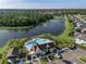 An aerial view of a community pool and clubhouse bordering a pond and wooded area at 12654 Oak Hill Way, Parrish, FL 34219