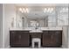 A luxurious bathroom featuring double sinks, a vanity with storage and a large mirror with modern lighting at 12654 Oak Hill Way, Parrish, FL 34219