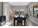 Bright dining room featuring a dark wood table, six chairs, and windows with backyard views at 12654 Oak Hill Way, Parrish, FL 34219