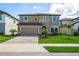 Charming two-story home with a well-manicured lawn, paver driveway, and neutral color palette at 12654 Oak Hill Way, Parrish, FL 34219