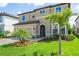Charming two-story home with well-manicured lawn, lush landscaping, and a paver driveway leading to a two-car garage at 12654 Oak Hill Way, Parrish, FL 34219