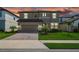 Beautiful two-story home with manicured lawn, paver driveway, two-car garage and tropical landscaping against a vibrant sunset at 12654 Oak Hill Way, Parrish, FL 34219
