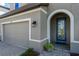 View of front door with decorative glass and sidelight, framed by an archway and lanterns at 12654 Oak Hill Way, Parrish, FL 34219