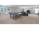 A spacious game room featuring a ping pong table, a comfortable sofa, and a large TV at 12654 Oak Hill Way, Parrish, FL 34219