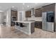 Modern kitchen with island, stainless steel appliances, dark wood cabinets, and tile flooring at 12654 Oak Hill Way, Parrish, FL 34219