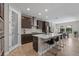 Modern kitchen featuring a large island with bar seating, stainless steel appliances, and stylish pendant lighting at 12654 Oak Hill Way, Parrish, FL 34219