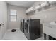 A practical laundry room featuring a washer, dryer, utility sink, and shelving at 12654 Oak Hill Way, Parrish, FL 34219