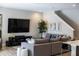 Comfortable living room with a large TV, gray sectional, and staircase at 12654 Oak Hill Way, Parrish, FL 34219