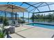 The screened in-ground pool features lounge chairs and views of the backyard and lake at 12654 Oak Hill Way, Parrish, FL 34219
