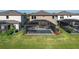 Backyard view of a screened-in pool, surrounded by green grass and mulch at 12654 Oak Hill Way, Parrish, FL 34219