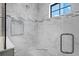 A modern, bright shower featuring marble tile, a shower niche, and a glass door at 12654 Oak Hill Way, Parrish, FL 34219