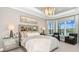 Spacious primary bedroom featuring a tray ceiling, chandelier, and large windows with beautiful views at 6237 Plateau Ct, Bradenton, FL 34203