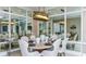 Elegant dining room with mirrored walls, modern light fixture, and a round dining table set for a meal at 6237 Plateau Ct, Bradenton, FL 34203