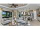 Open concept living room with couches, leading into the kitchen with stainless steel appliances and barstool seating at 6237 Plateau Ct, Bradenton, FL 34203