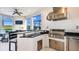 Outdoor kitchen with stainless steel grill, bar seating, and scenic views of pool and lake at 6237 Plateau Ct, Bradenton, FL 34203