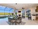 Covered patio with outdoor dining set, fireplace, bar area, and scenic lake view with a pool at 6237 Plateau Ct, Bradenton, FL 34203