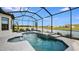 Screened in pool and spa overlooking the lake with two lounge chairs on the deck at 6237 Plateau Ct, Bradenton, FL 34203
