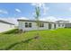 A well-maintained backyard featuring a patio, lush green lawn, and young tree at 31622 Malbec Ln, Brooksville, FL 34602