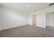 A spacious bedroom with plush carpet and a doorway leading to a bathroom at 31622 Malbec Ln, Brooksville, FL 34602
