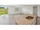 Kitchen island with granite countertops, stainless steel sink, and view of living space and backyard at 31622 Malbec Ln, Brooksville, FL 34602