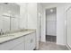 Bathroom featuring a double vanity, granite countertops, walk in shower, and access to walk-in closet at 31673 Wild Grape Sw Ln, Brooksville, FL 34602