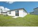 A spacious backyard featuring a sliding glass door entrance and lush green grass at 3568 Moscato Dr, Brooksville, FL 34602