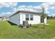 An exterior view of a home's backyard featuring healthy grass, landscaping, and an AC unit at 3568 Moscato Dr, Brooksville, FL 34602