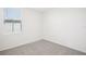 A bright bedroom featuring neutral carpet, white walls, and a window with blinds at 3568 Moscato Dr, Brooksville, FL 34602