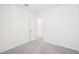 Bright bedroom featuring neutral carpet, white walls, and a door leading to another room at 3568 Moscato Dr, Brooksville, FL 34602