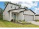 Inviting home with a two-car garage, covered entry, and lush landscaping enhancing curb appeal at 3824 Radiant Mountain Dr, Plant City, FL 33565