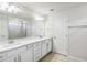 Bathroom featuring a double sink vanity with white cabinets and light countertops and a large mirror at 12963 Brookside Moss Dr, Riverview, FL 33579