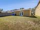 Spacious backyard with lush green grass, a privacy fence, and sliding glass doors at 5211 Mango Fruit St, Seffner, FL 33584