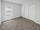 Bright bedroom featuring a large window, spacious closet and modern hardwood flooring at 5211 Mango Fruit St, Seffner, FL 33584