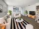 Bright living room featuring a white sofa, a black and white striped rug, and stylish decor at 5211 Mango Fruit St, Seffner, FL 33584