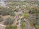 Aerial view of a home on a large lot, surrounded by mature trees and additional buildings at 3634 Apfel Rd, Wesley Chapel, FL 33543
