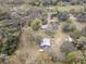 Expansive aerial view of a large lot featuring a barn, a manufactured home, and mature trees creating a private setting at 3634 Apfel Rd, Wesley Chapel, FL 33543